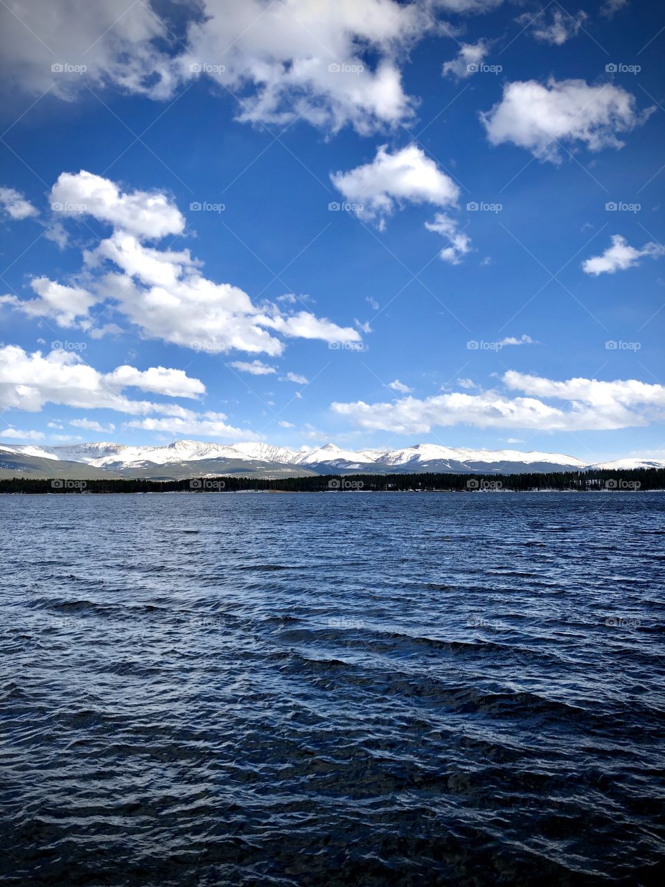 A windy day on the lake under passing clouds.