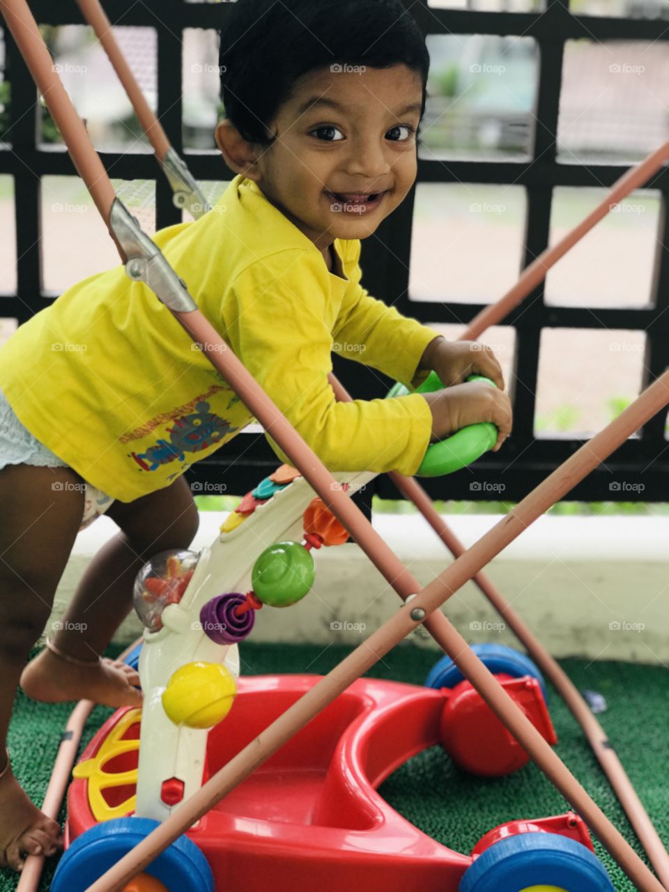 Indian baby boy in yellow shirt with cute smile 