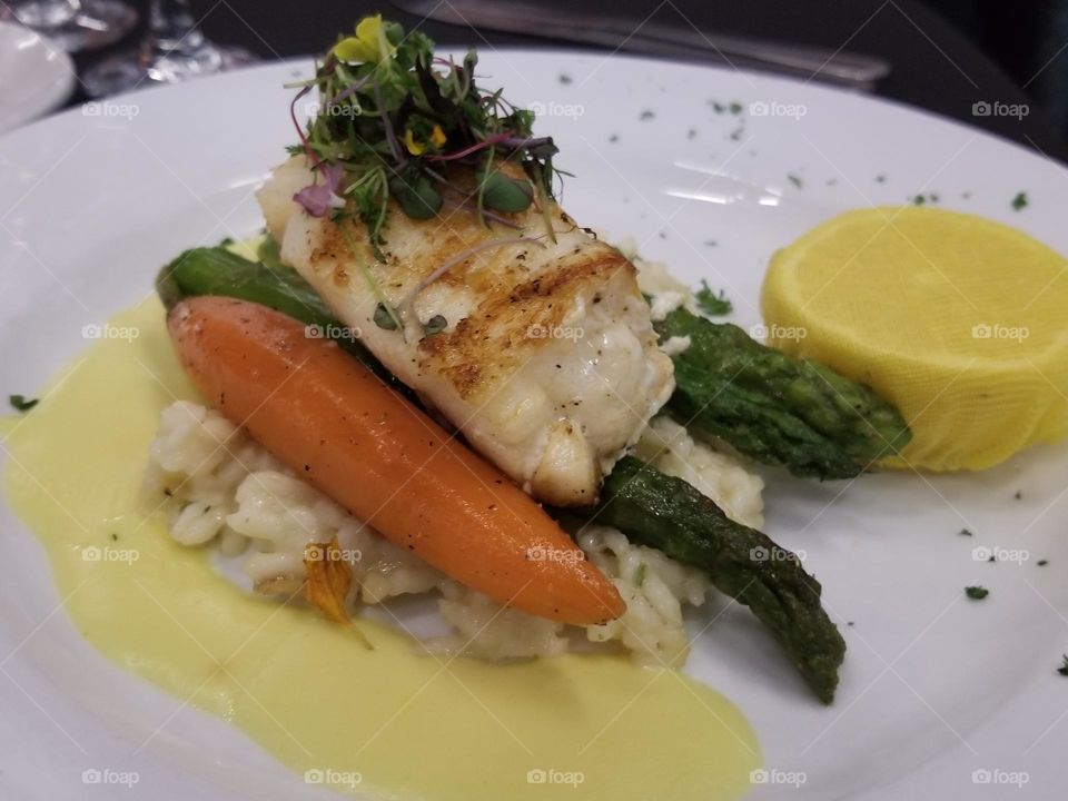 Grilled halibut on a bed of risotto with asparagus and carrots, topped with micro greens and a luscious bernaise sauce. Lemon to give the right amount of acidic tartness