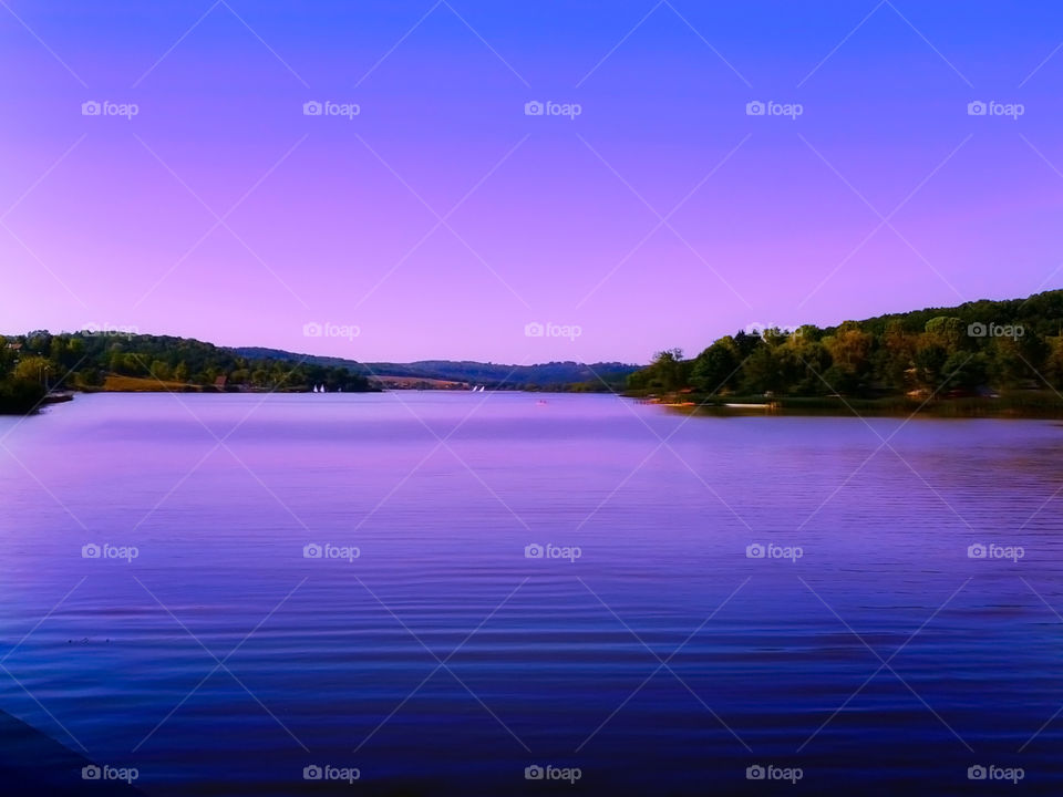Orfű Lake at sunset in purple lights, in Hungary. Soft focus.