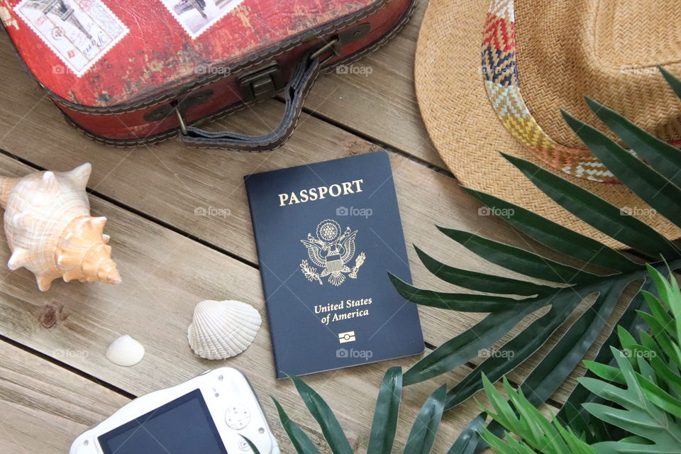 Travel items flat lay with hat suitcase passport usa camera