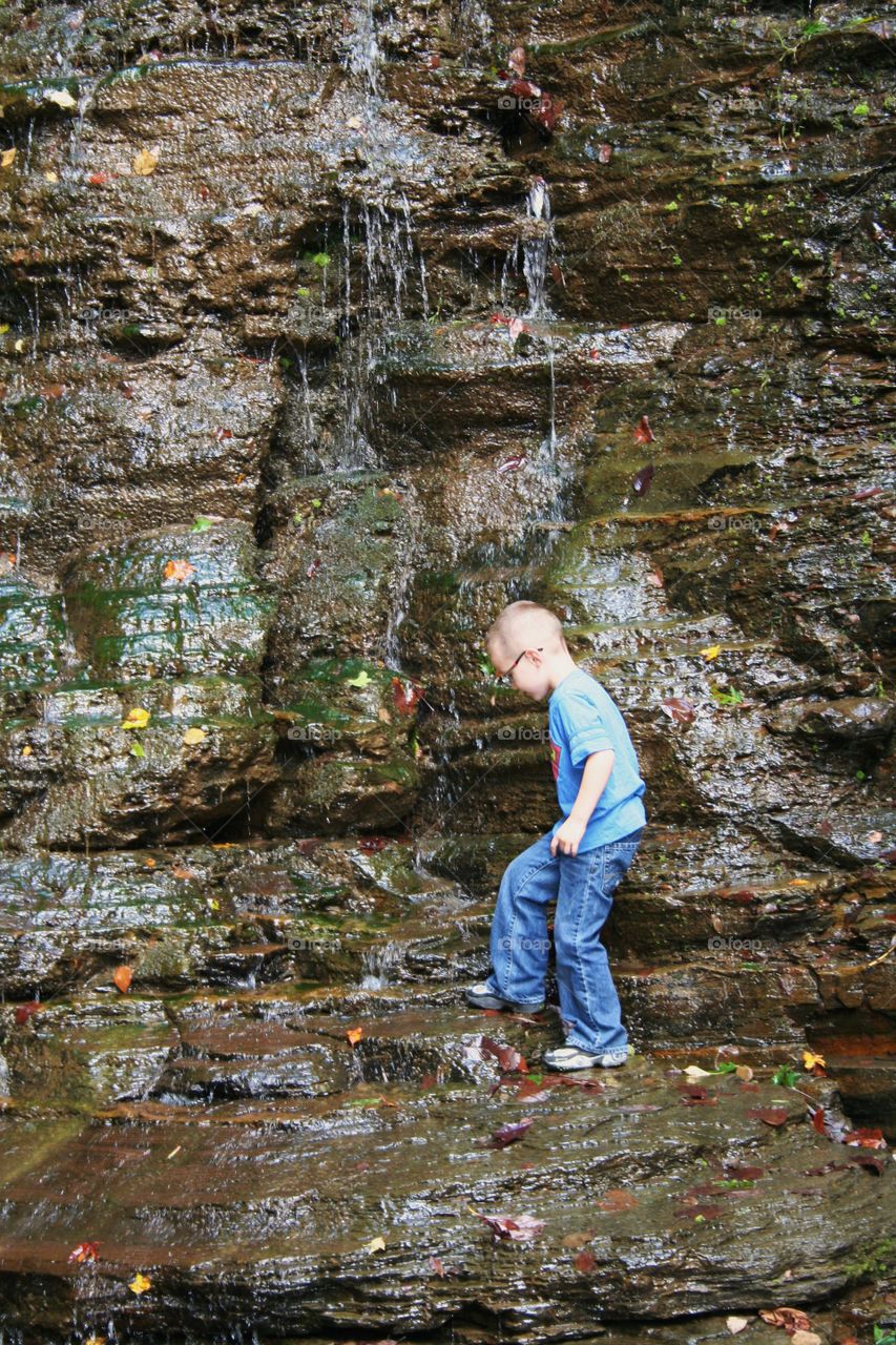 Small boy enjoying waterfall