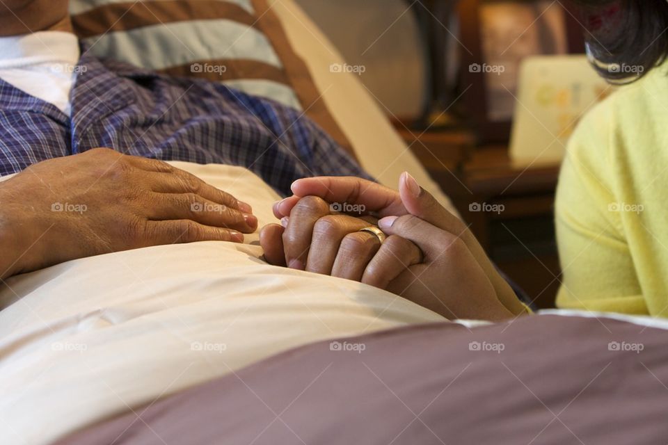 Caregiver holding patients hand