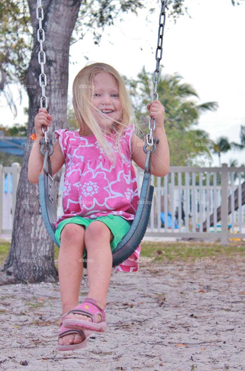 Young little girl swinging