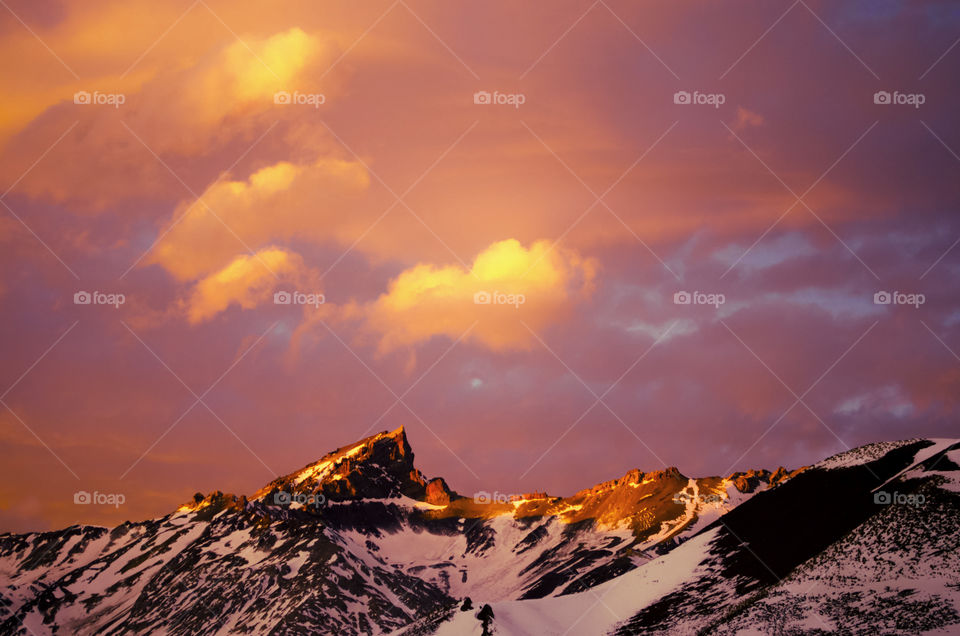 mountain peek over a sunset sky