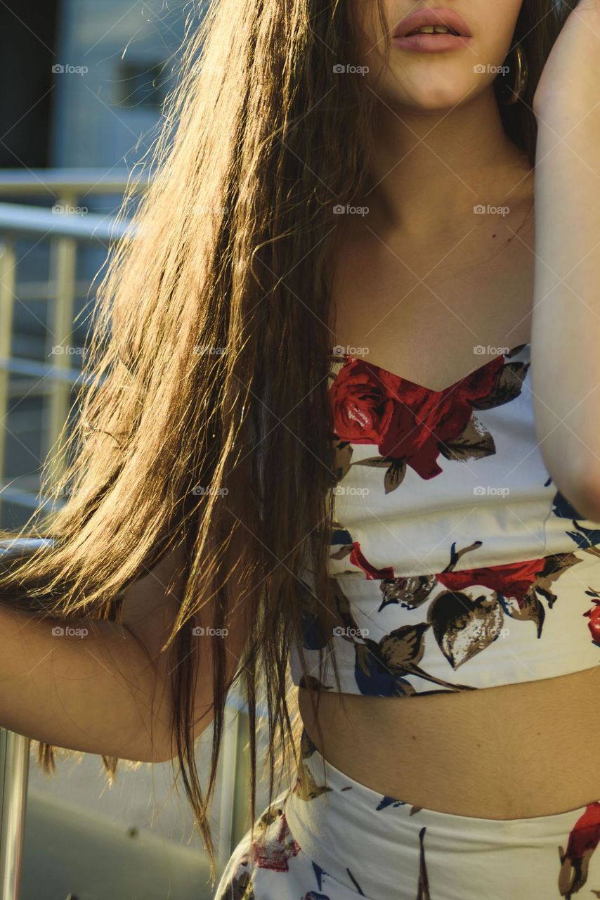 A girl with long beautiful hair on a summer day in the rays of the setting sun.