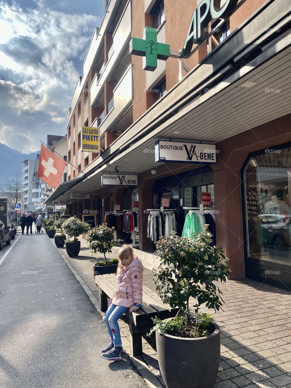 Swiss street, girl sitting on a bench