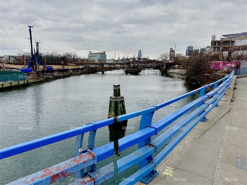 This is the “Borden Avenue Bridge” over “Dutch Kills”, an ocean inlet of the “East River” in LIC, Queens on an overcast day in December 2023. Across the water we can see the arched structure of an old railroad bridge. Hypnotic Productions