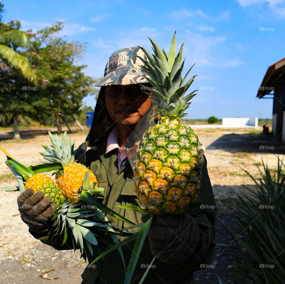 A man holding the pineapples