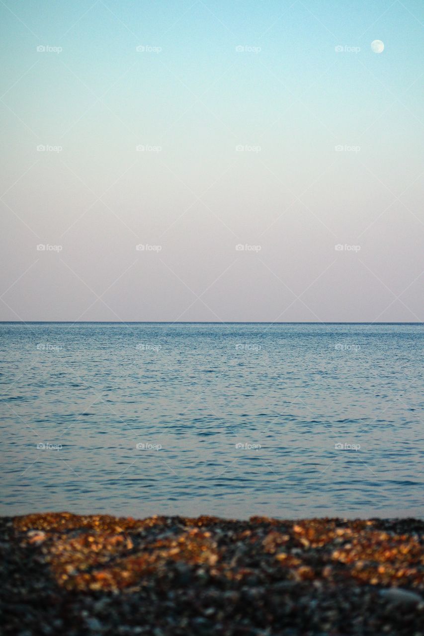 Beach Sea Sky Moon. Searching the moon in the day light in a beach in Rhodos island Greece 