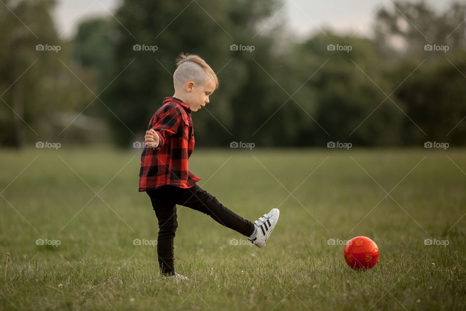 Little boy playing in soccer in a park 