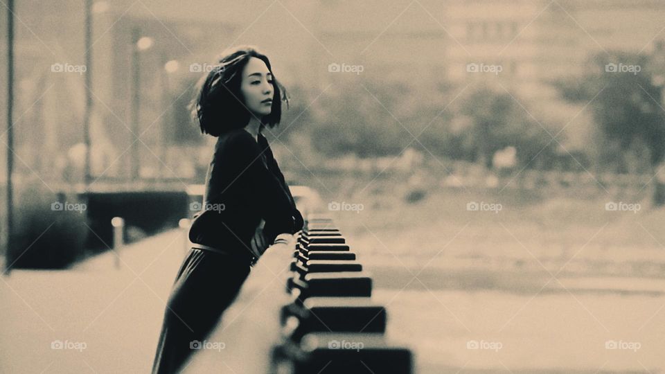 The lady leaned on the railing and stared into the distance.