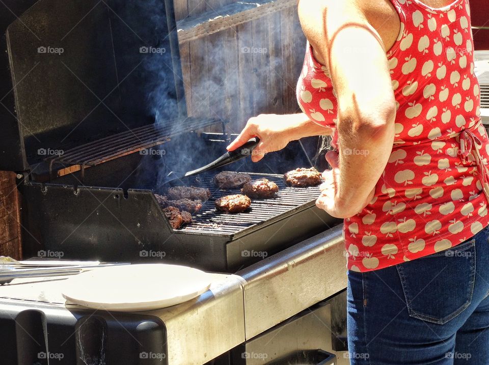 Mom Flipping Burgers On The Grill