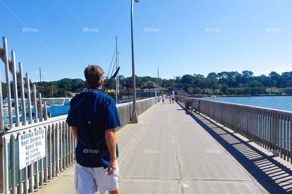 Man walking on a pier on the beach 