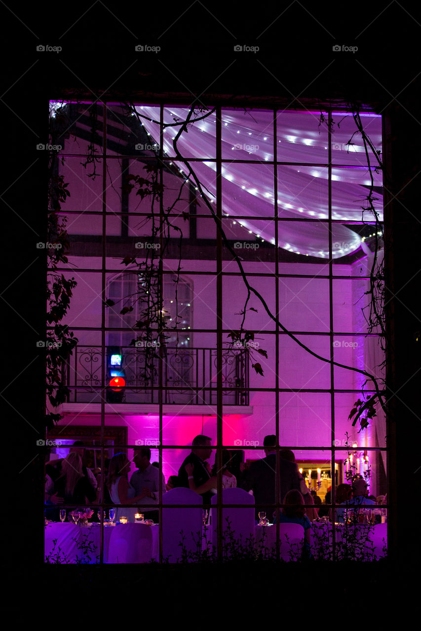 Love the feel of this photo created by the purple lights and fairly lights. Image of people dancing taken from outside.