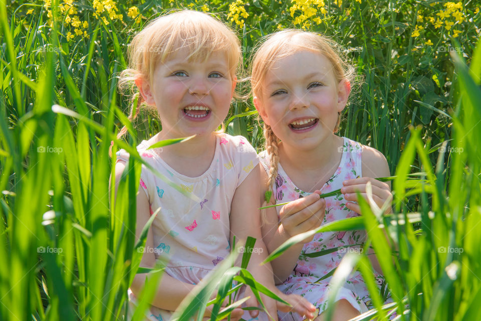 Happy sisters sitting in grass