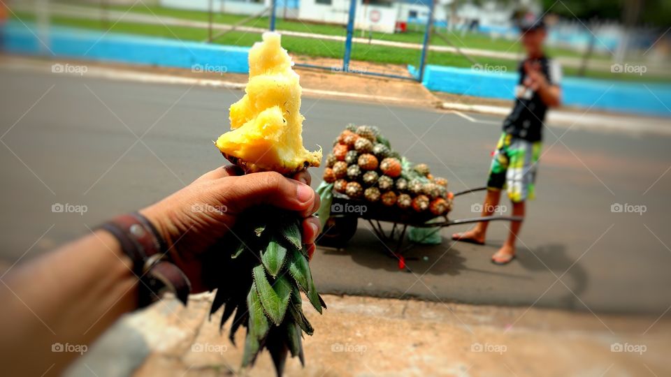oferecendo um pedaço de abacaxi ao vendedor ambulante de frutas