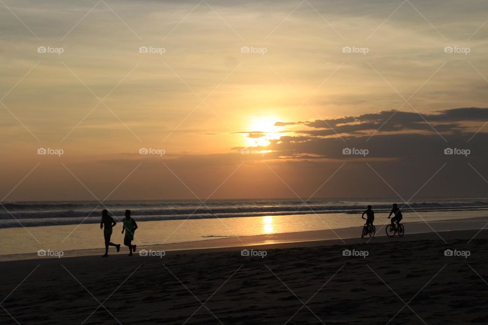 Panoramic sunset and coastline views during active and leisure hours in Seminyak area of Bali island. 