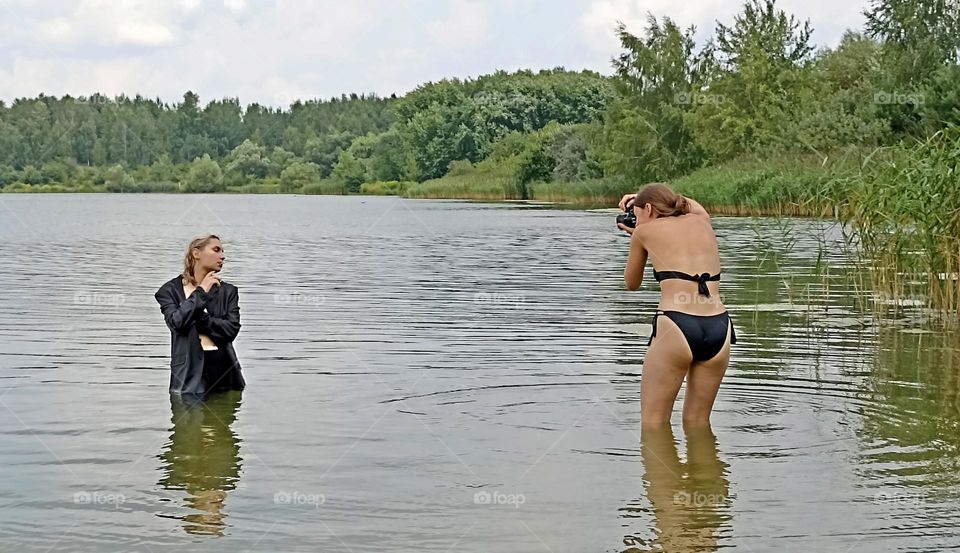 photographer and model girls in water lake take picture summer time