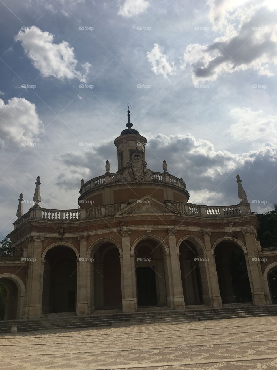 The main cathedral in Aranjuez, Madrid stand tall in the image with so many amazing details. From the column pillars holding up the arches and the  the smaller pillar reaching up to the sky filled with flush clouds. This cathedral looks heavenly. 
