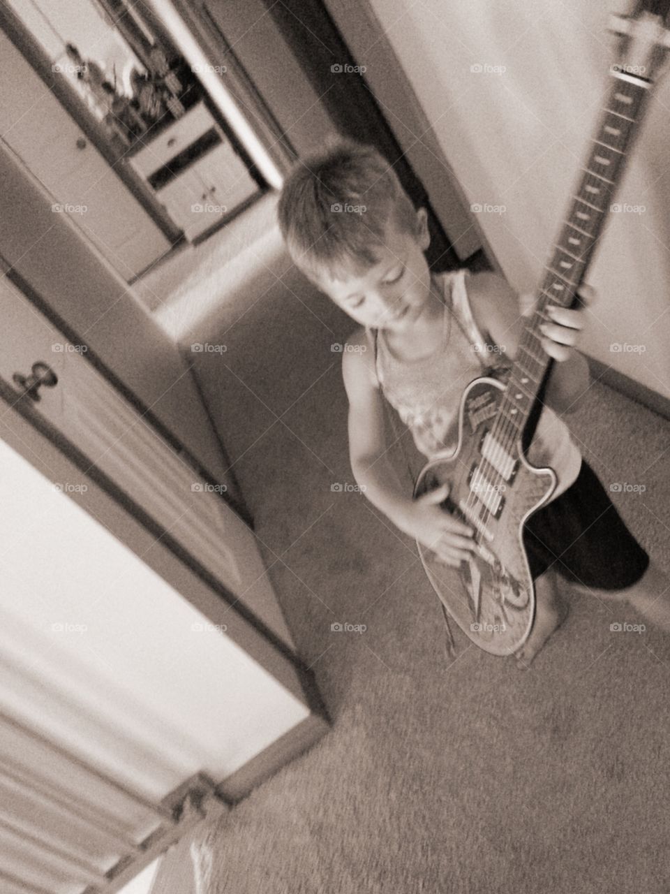 Boy playing guitar in black and white