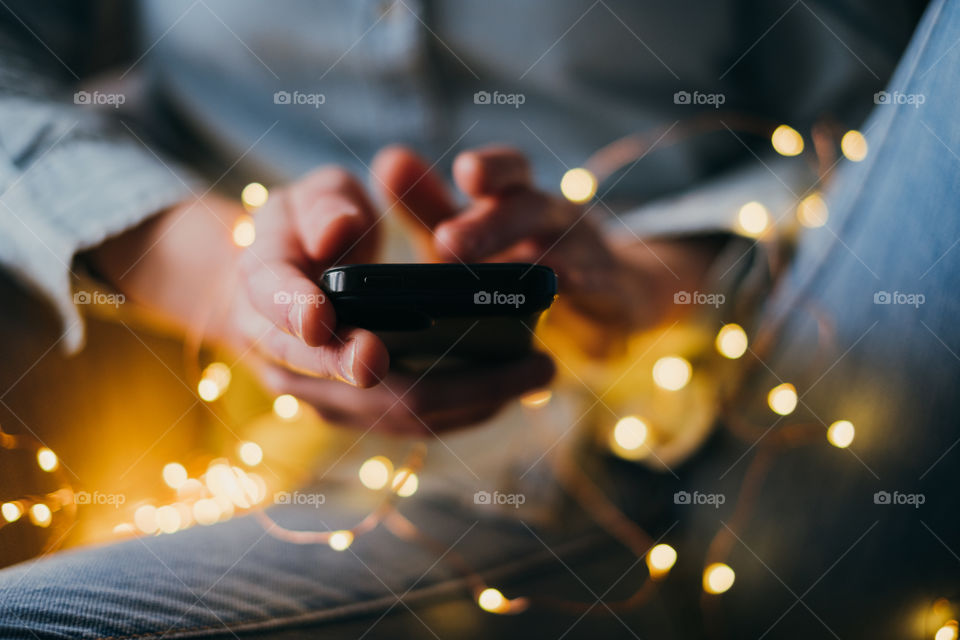 Woman using mobile device at Christmas lights 