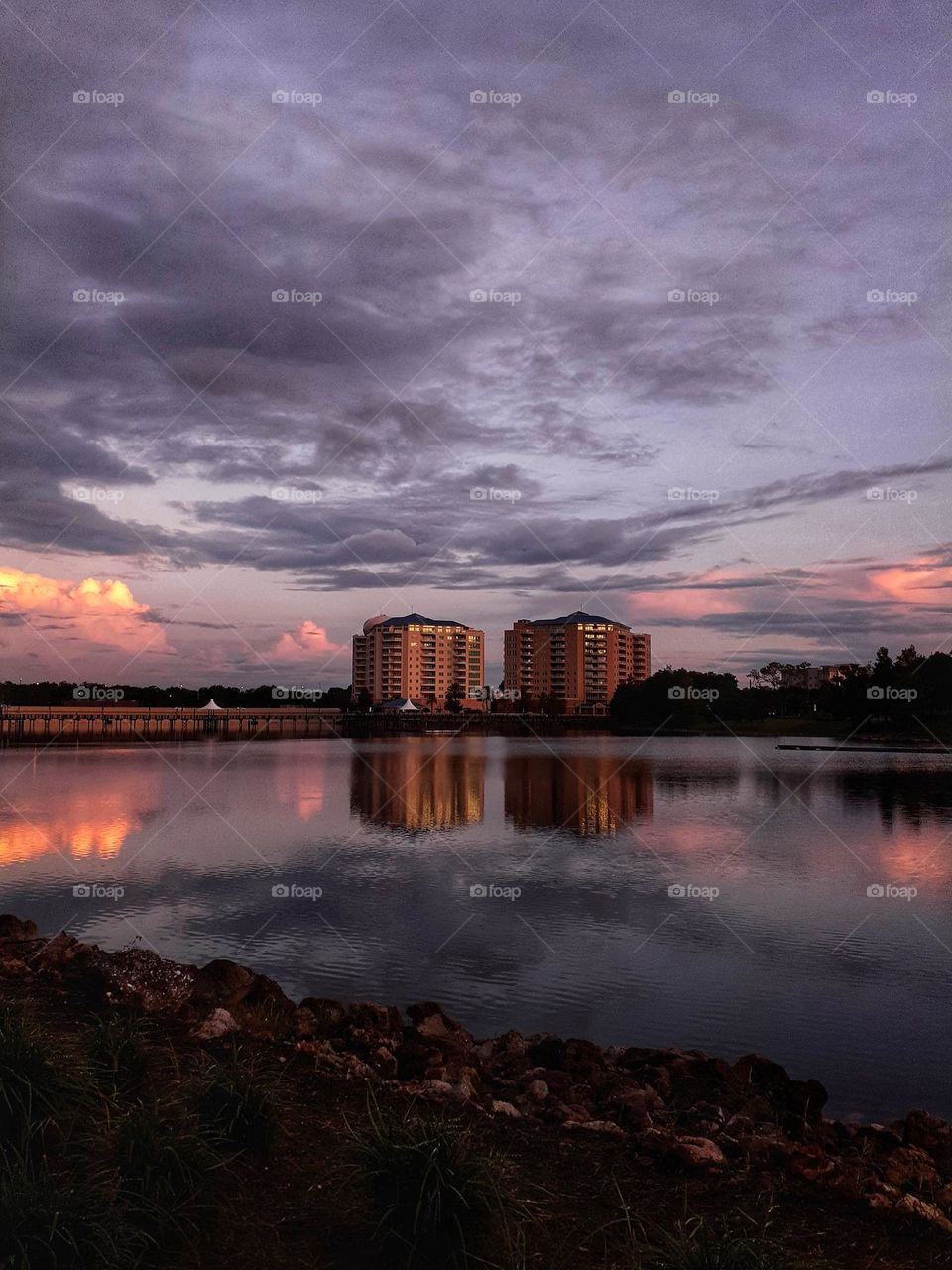 A beautiful lakescape at Sunset with a cloudy sky with reds and yellows and grays at Cranes Roost Park in Altamonte Springs, Florida.