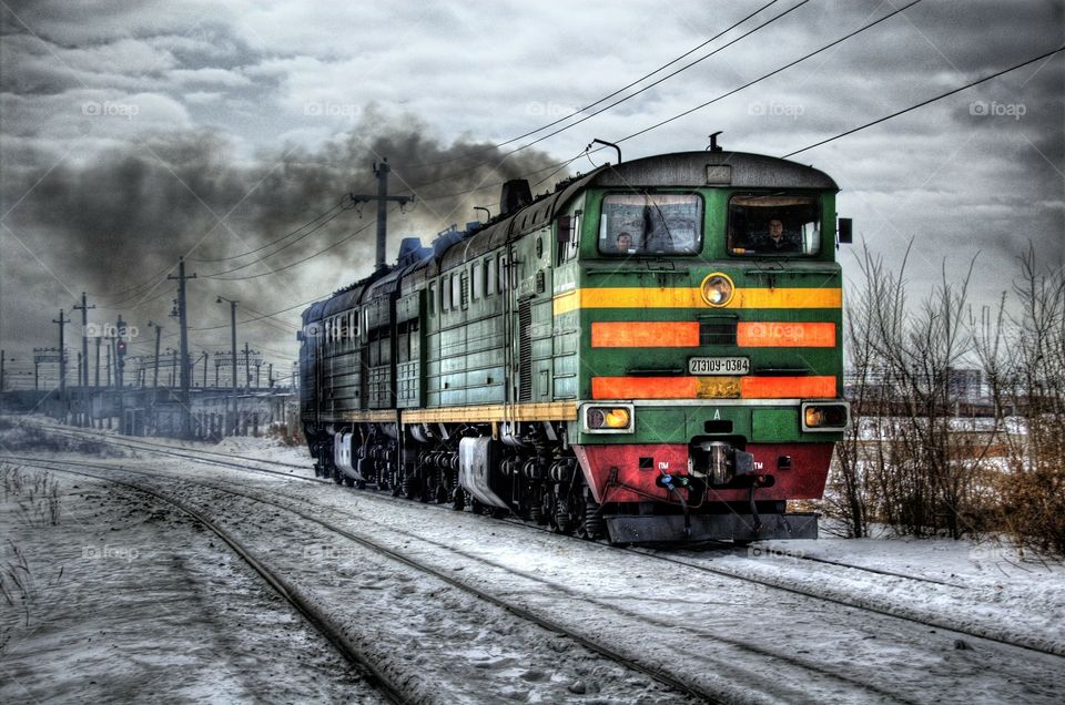 train in siberia arriving at station with snowy landscapes in the background.