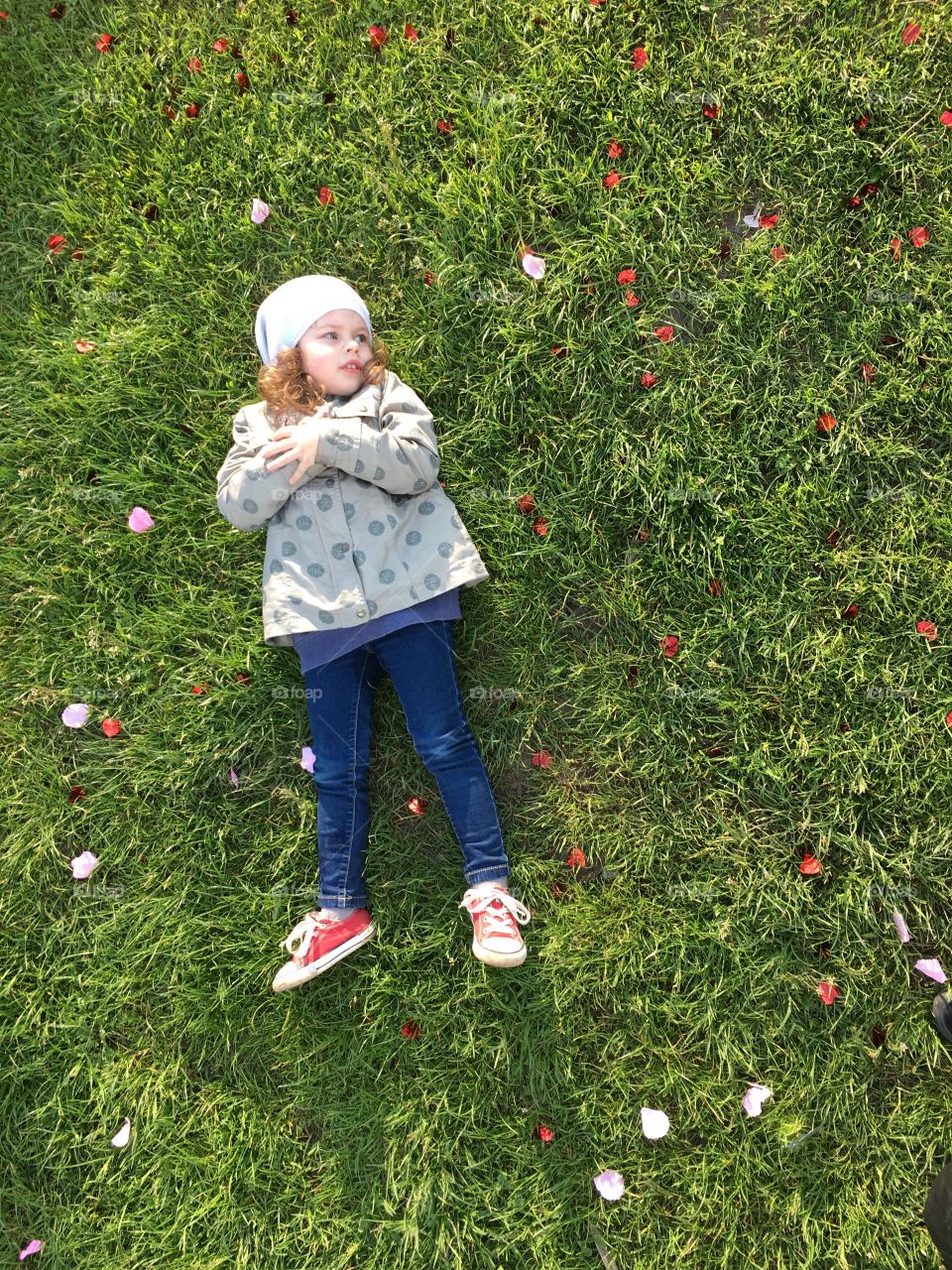 Funny cute girl lying on the grass 