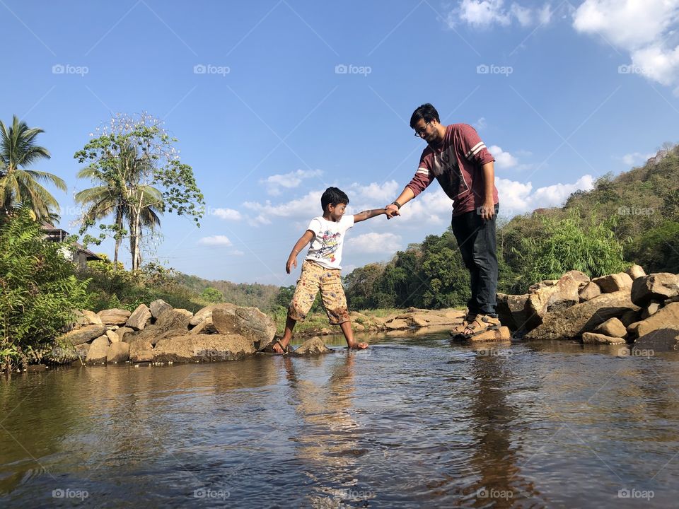 Capture the love and trust between a father and son in this serene photo. Shot in the great outdoors, this image is perfect for family-oriented marketing materials or travel blogs. Experience the beauty of nature and the bond between family members.