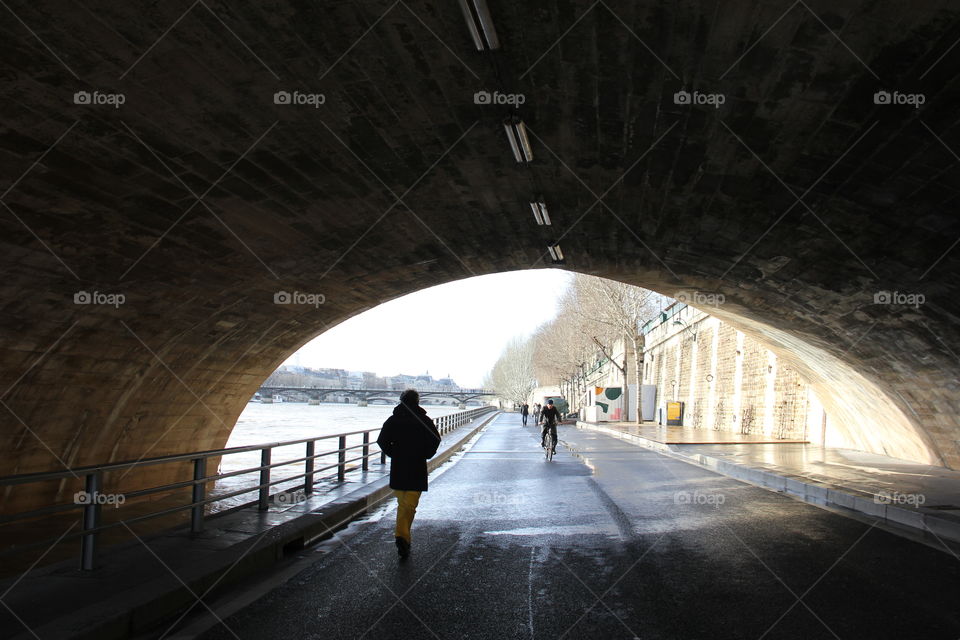 People walking under the bridge