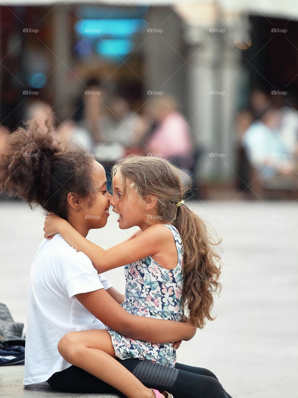 Two little cute smiling girls in a conversation