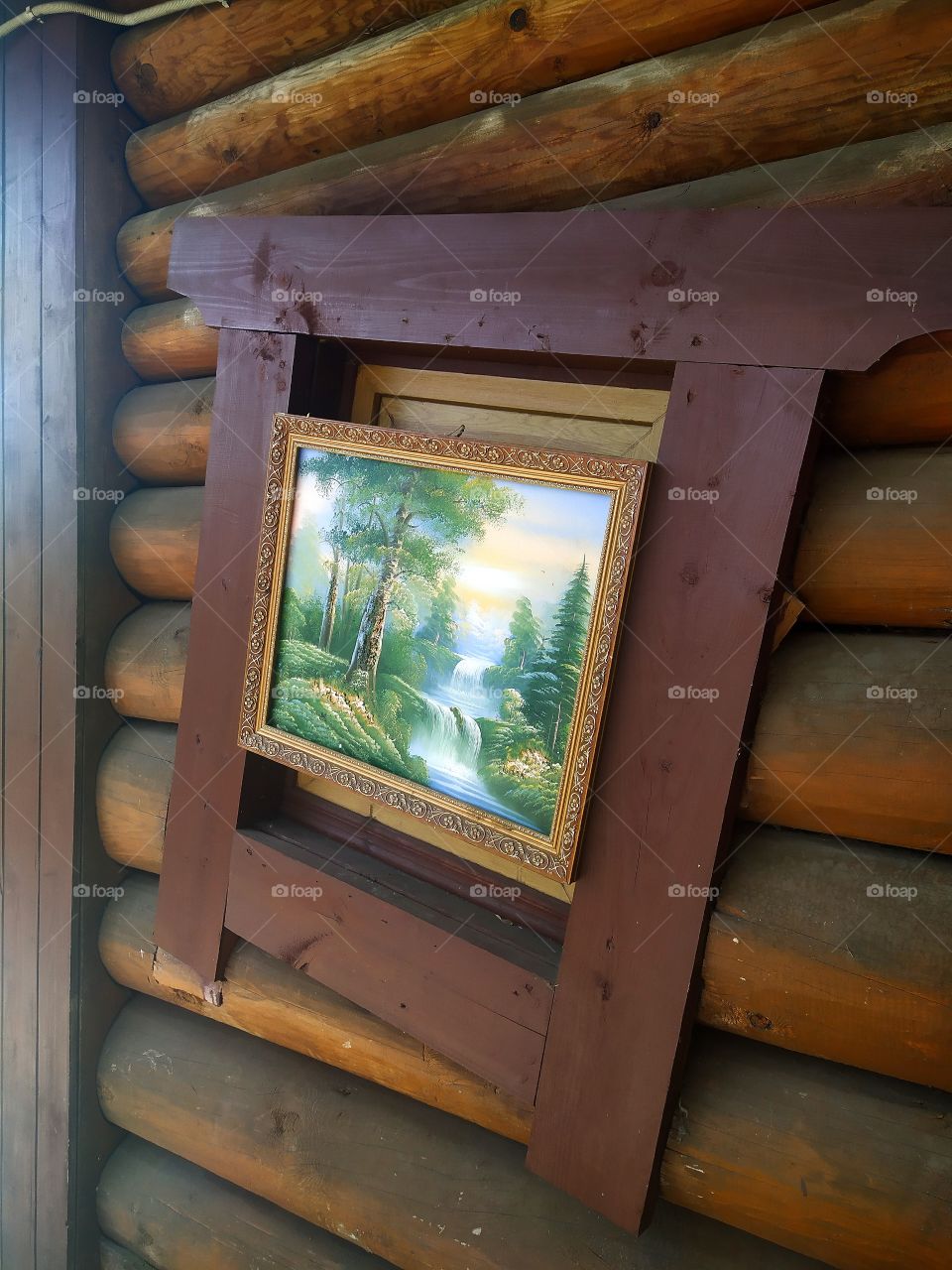 Picture in a rickety frame on the wooden wall of an old house