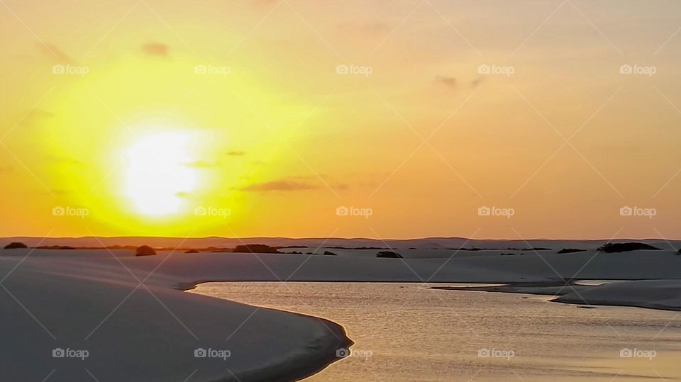 River and white sand dunes at sunset 