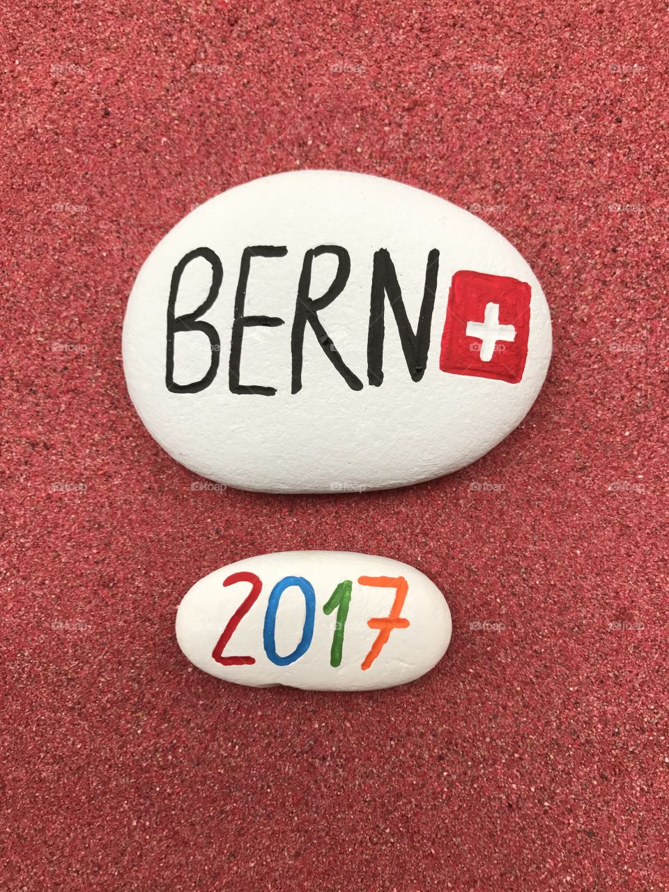 Bern 2017 on carved and colored stones over red sand 