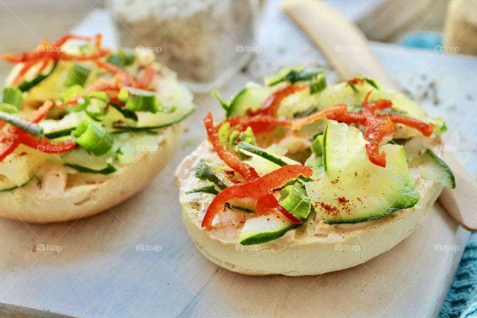 Salmon spread with thinly sliced cucumber, red pepper, and green onion on toasted bagel 🥯