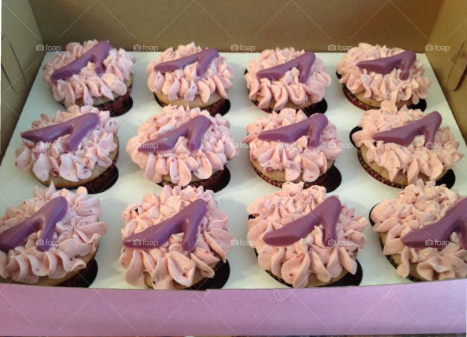 Vanilla cupcakes with purple chocolate high heel shoes on top for decoration. 