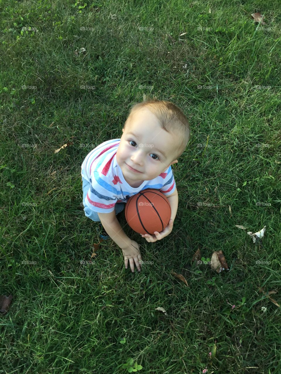 Elevated view of a boy holding basket ball in hand