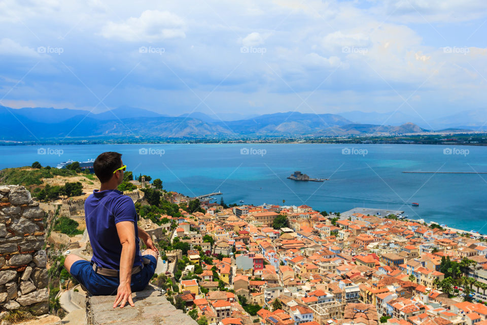 Stretching with great view. Stretching man on top of hill with Nafplio panorama view