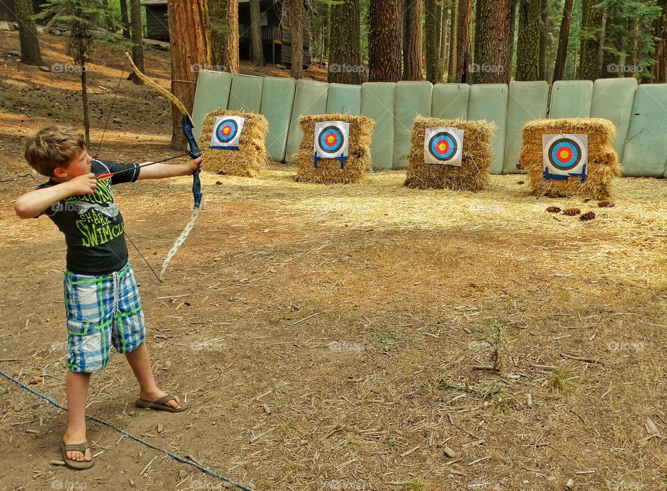 Target Practice. Boy Shooting Arrows At The Archery Range
