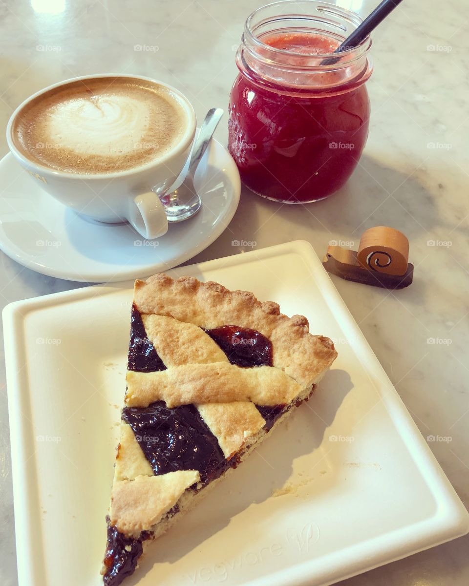 Healthy breakfast time with a cappuccino, prune tart and a centrifuged of red turnips