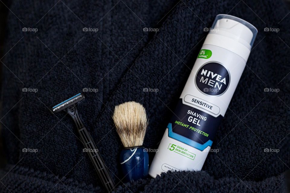 Nivea Men sensitive shaving gel with brush and razor on dark blue bathrobe 