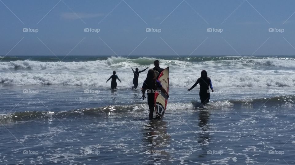 Summer at the beach teaching kids to surf