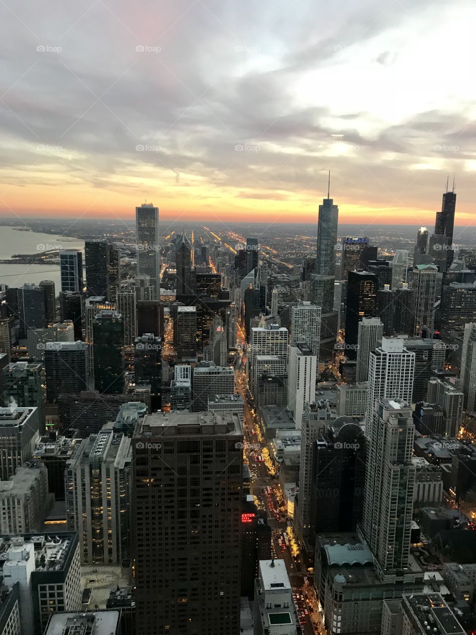 Colorful sunset behind a beautiful section of the Chicago skyline taken from the aerial advantage of the Signature Lounge
