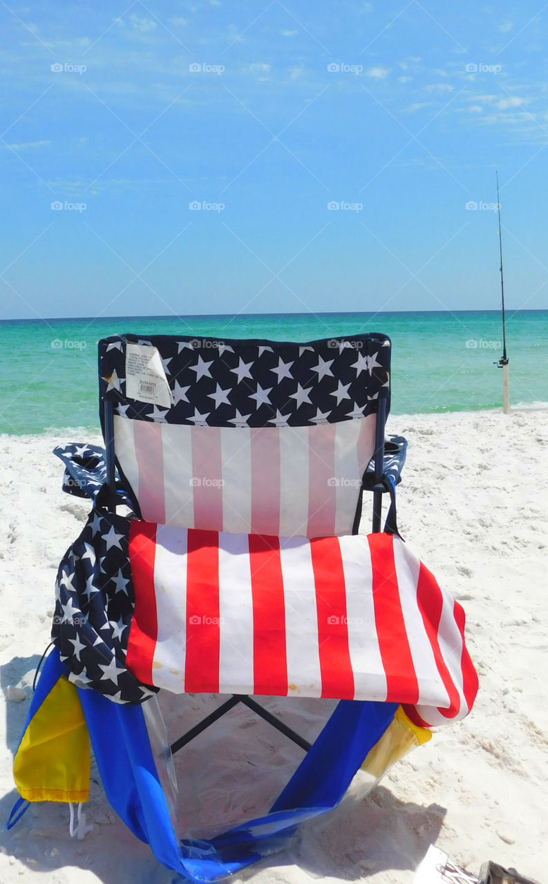 Chair covered with american flag at beach