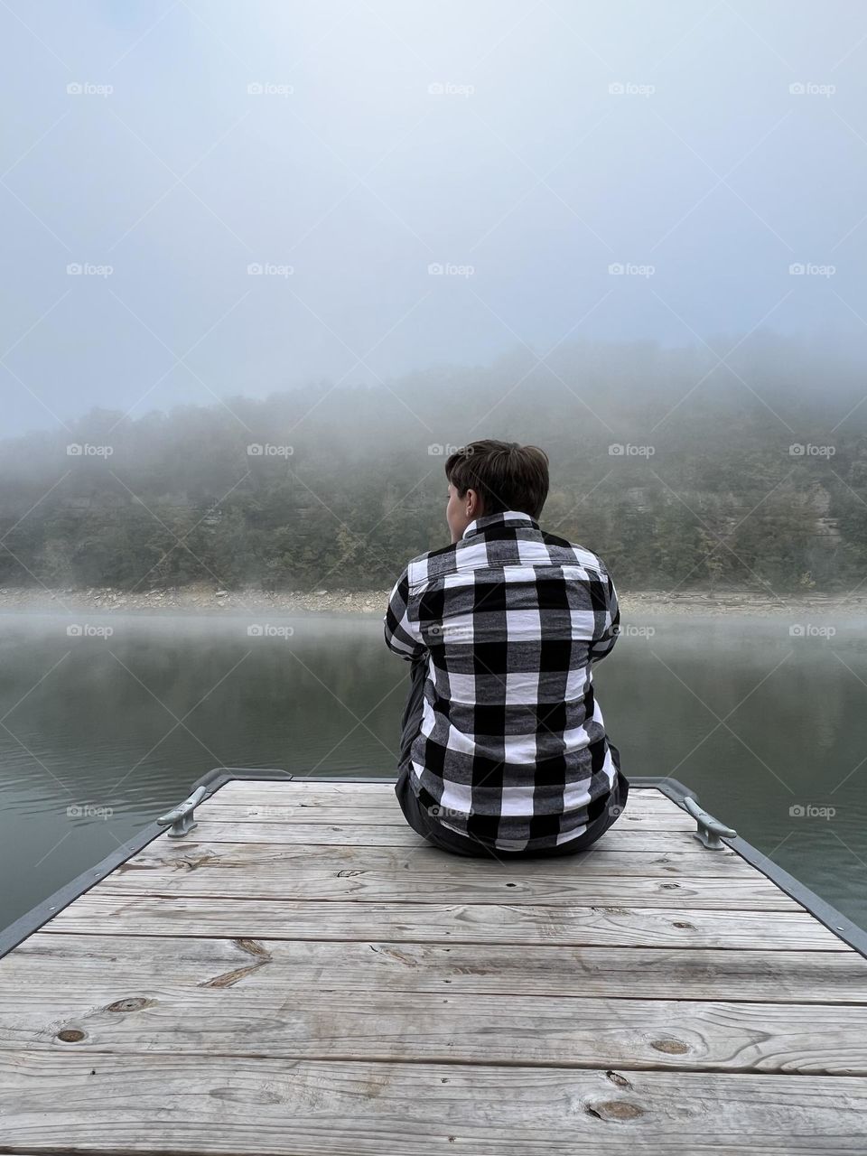 A young man enjoying a peaceful morning on the dock