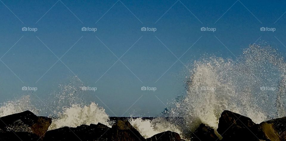 Waves breaking over the jetty