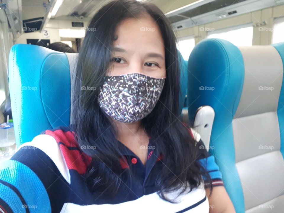 Mature woman taking selfie while sitting on the train
