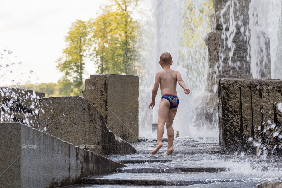 a boy playing in fountain