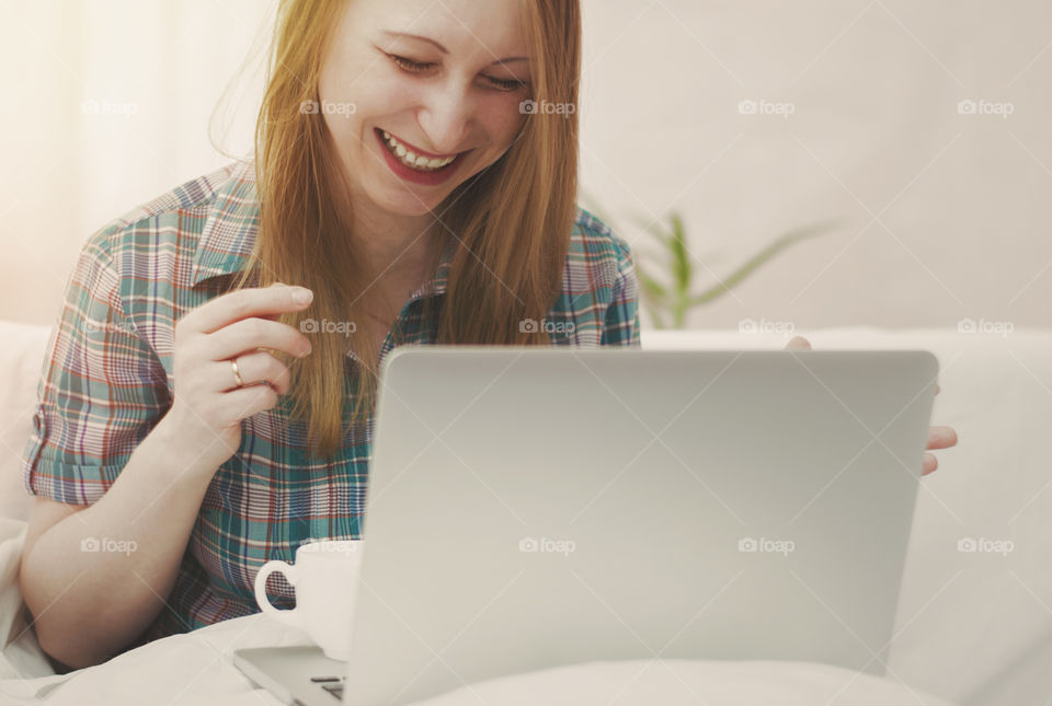 Girl working for the laptop. Girl laughs working for the laptop.
